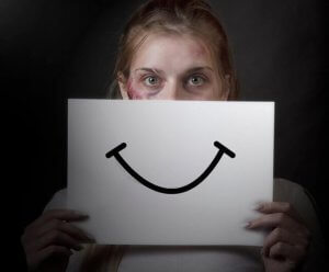 domestic abuse victim with paper smile